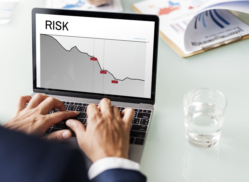 Business professional reviewing a declining risk chart on a laptop