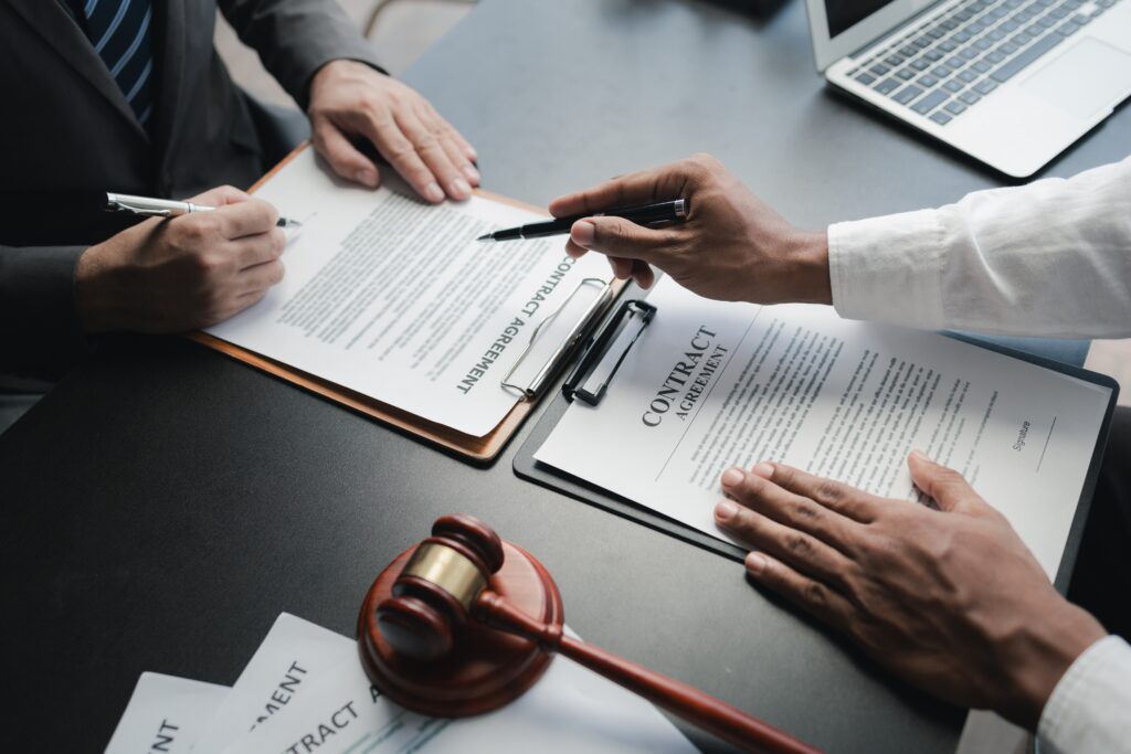 Professionals reviewing a contract agreement with a legal gavel